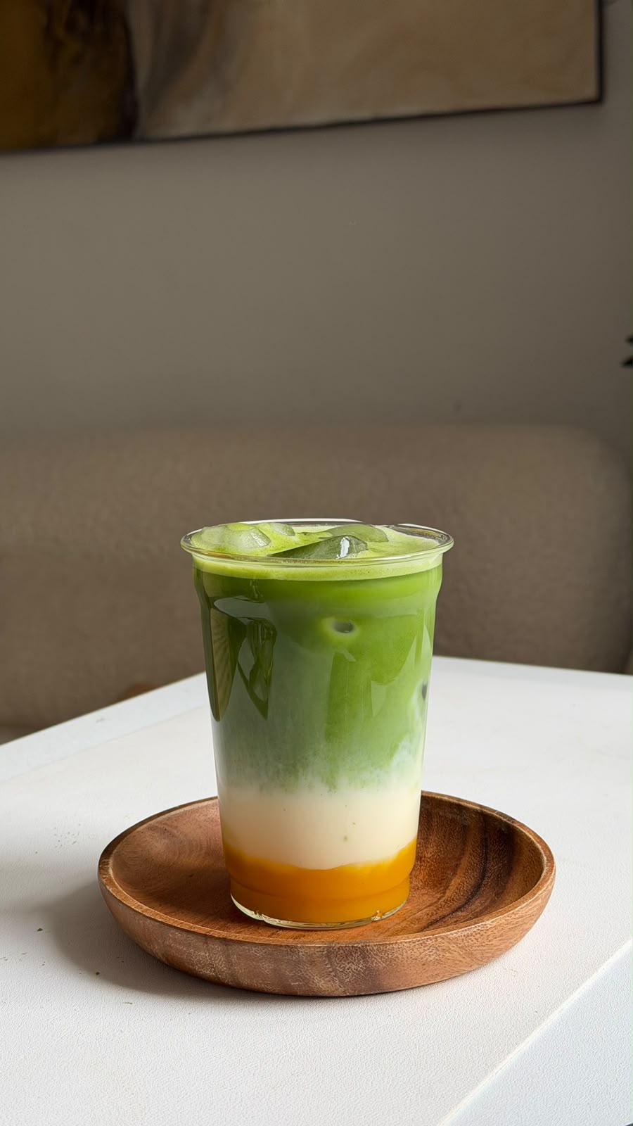Mango Matcha Latte mit gelber Mangoschicht, Milch und grünem Matcha im Glas
