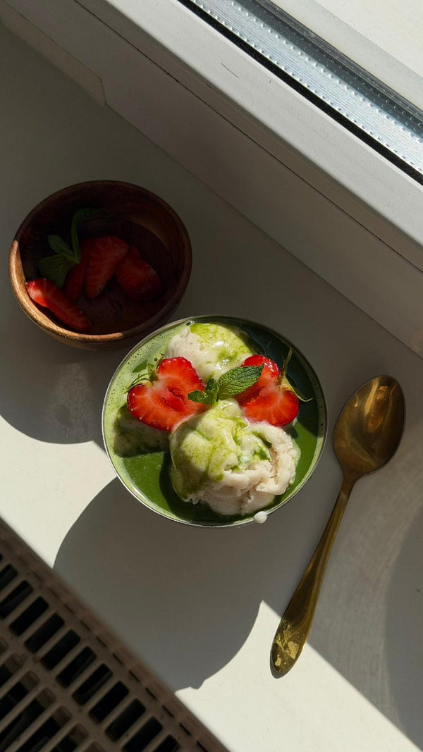 Vanilleeis mit grünem Matcha, Erdbeeren und Minzblättern in einer silbernen Eisschale