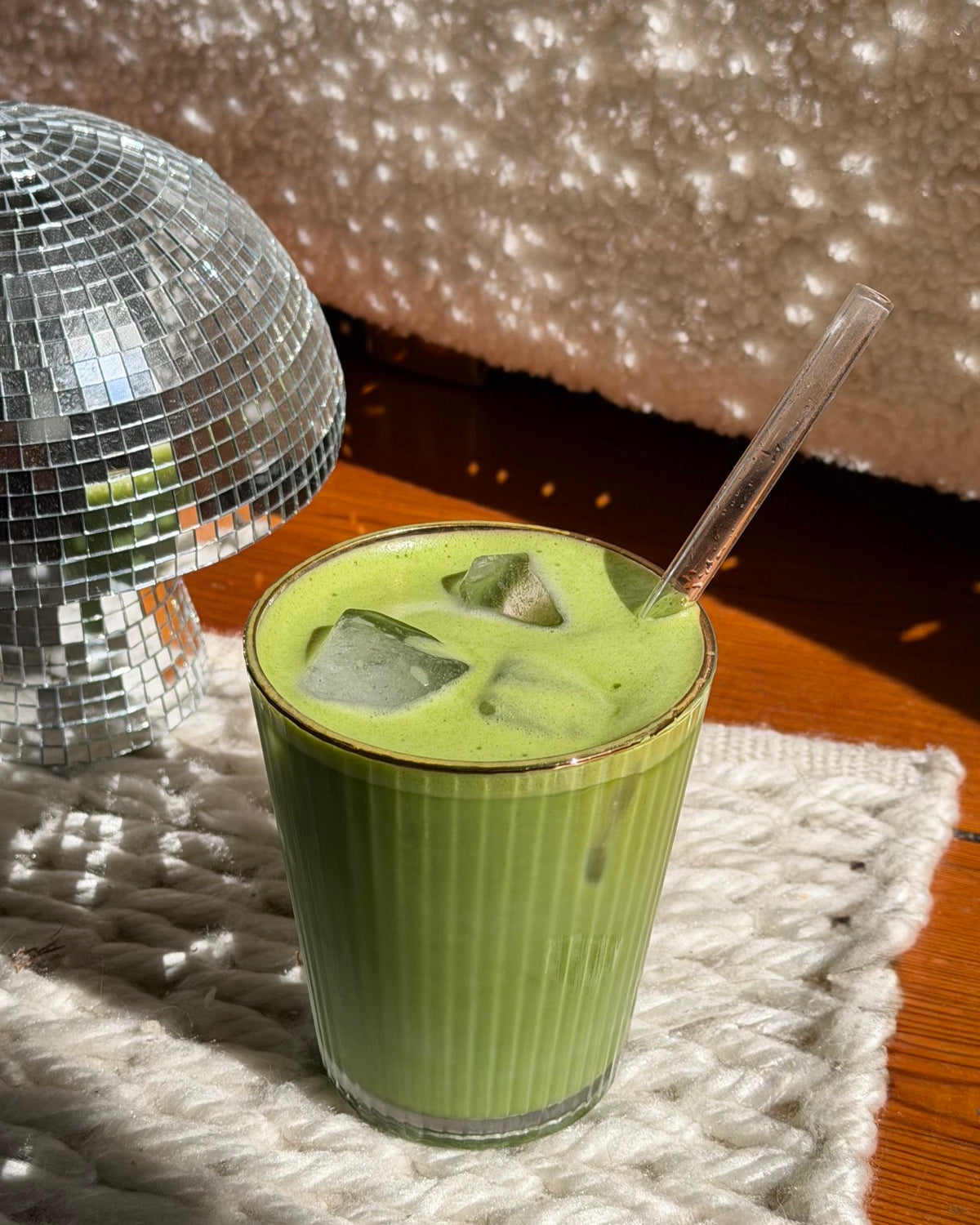 Iced Matcha Latte neben einer Discokugel